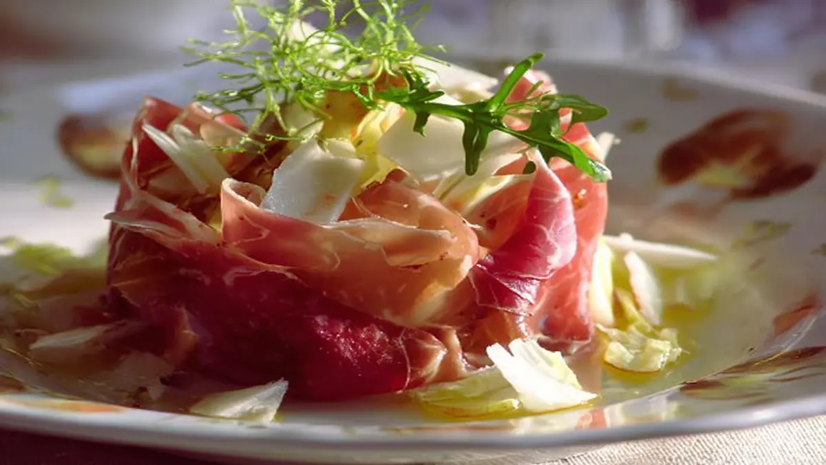 carpaccio de jambon cru avec copeaux de parmesan, roquette et filet d'huile d'olive