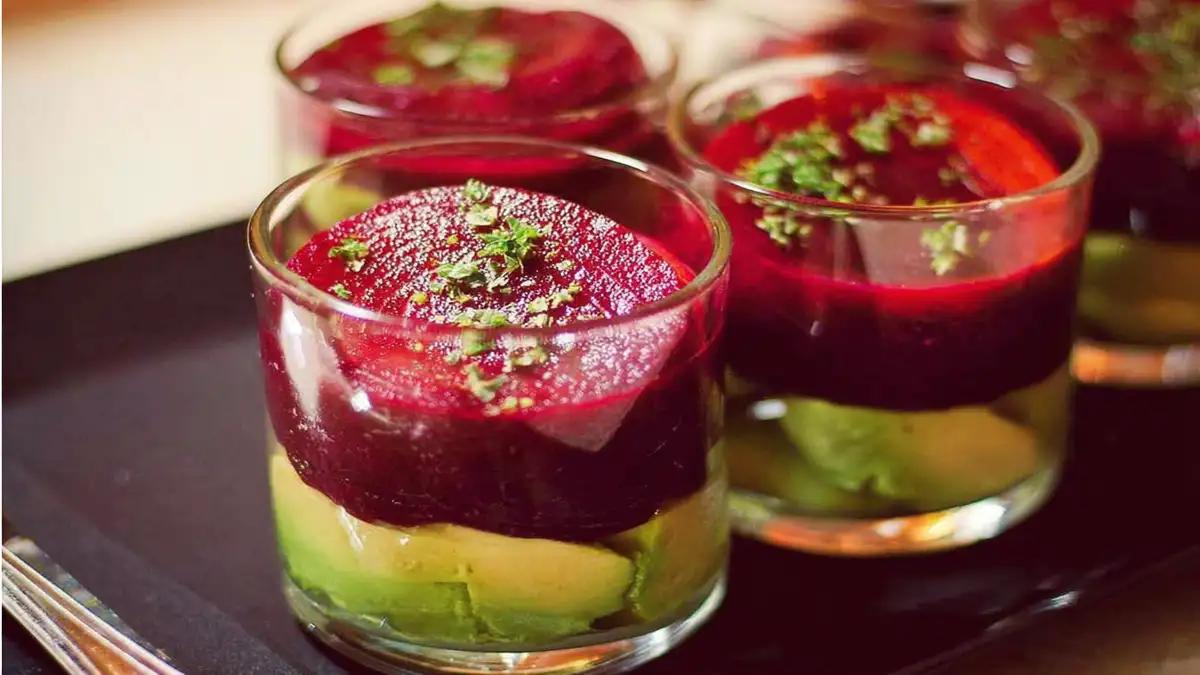 verrines colorées avec purée d’avocat et rondelles de betterave, garnies de persil frais